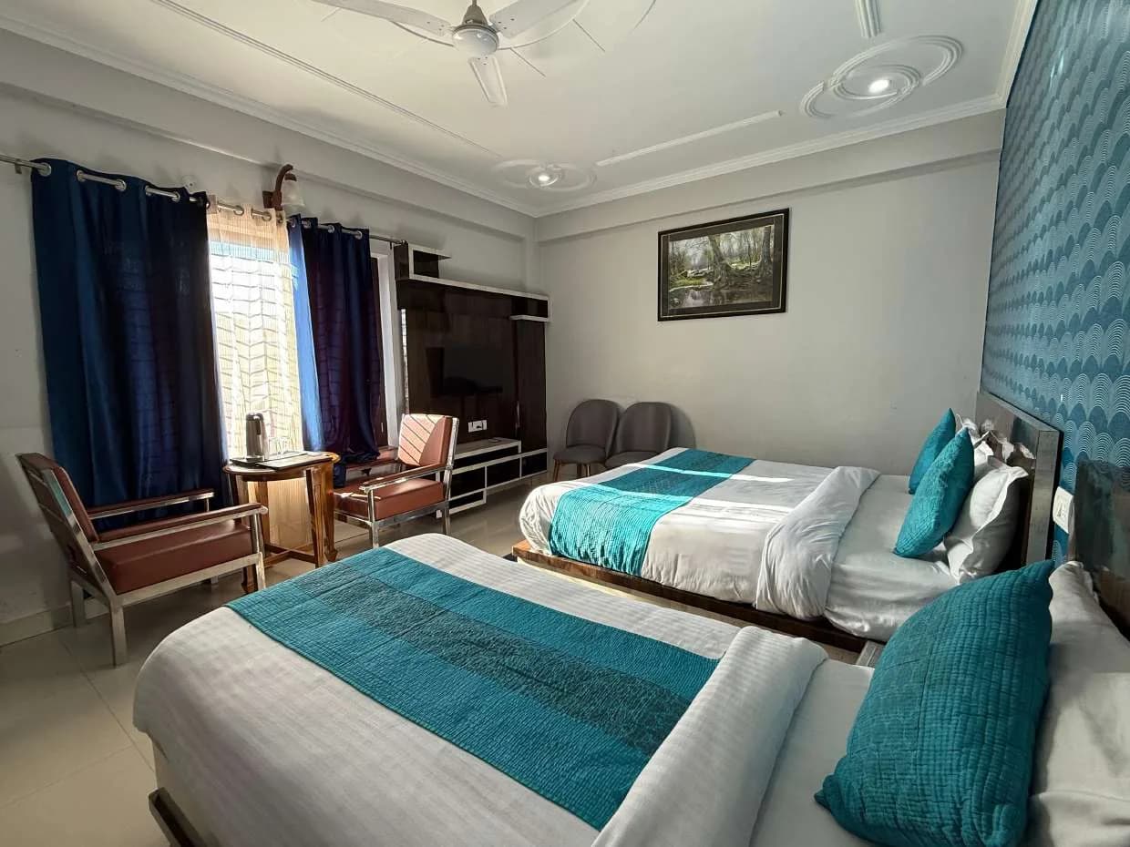Room with two beds, TV unit and seating by the window