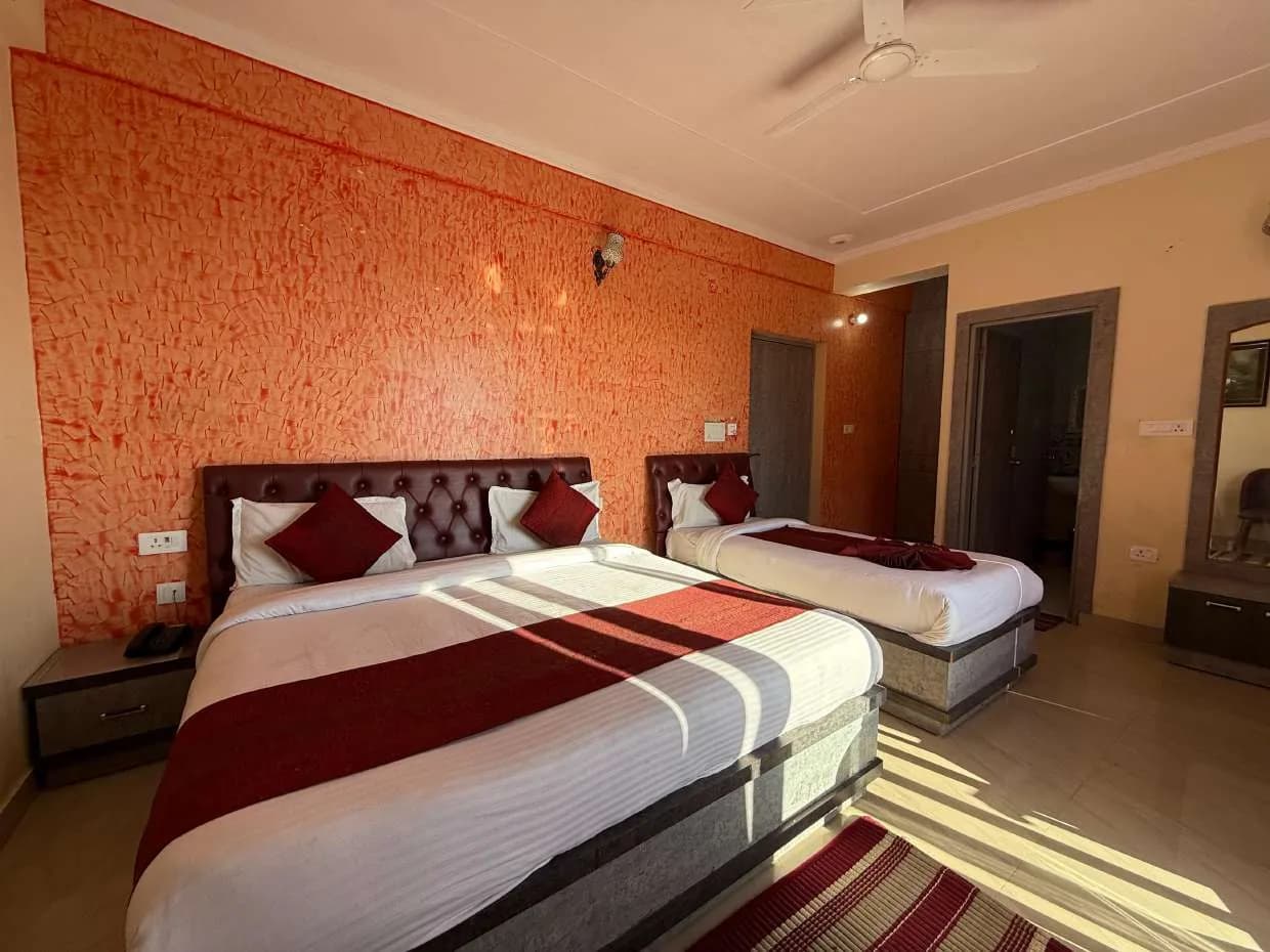 Room with a double bed and a smaller bed against an orange textured wall