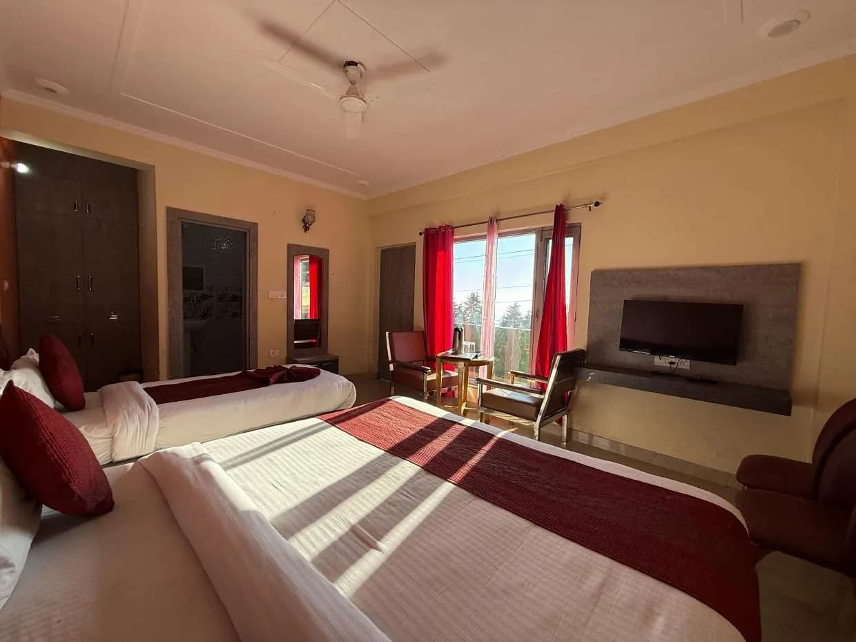 Room with two beds, red curtains and a tea table by a large window